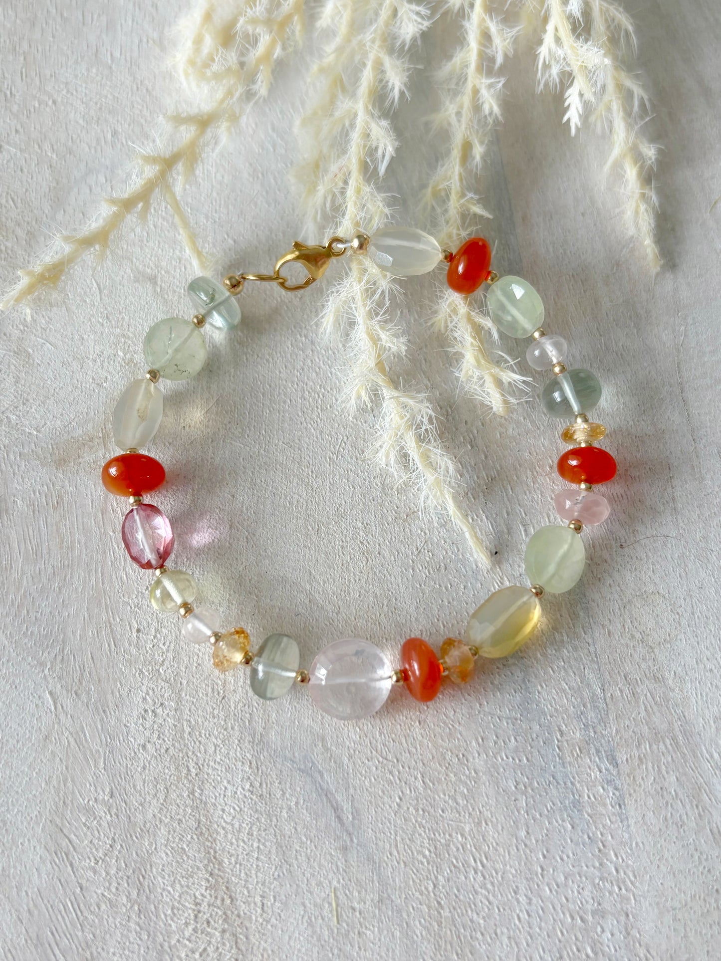 Multi Gemstone Bracelet 7.75 inch with various colored beads and a gold clasp on a white surface