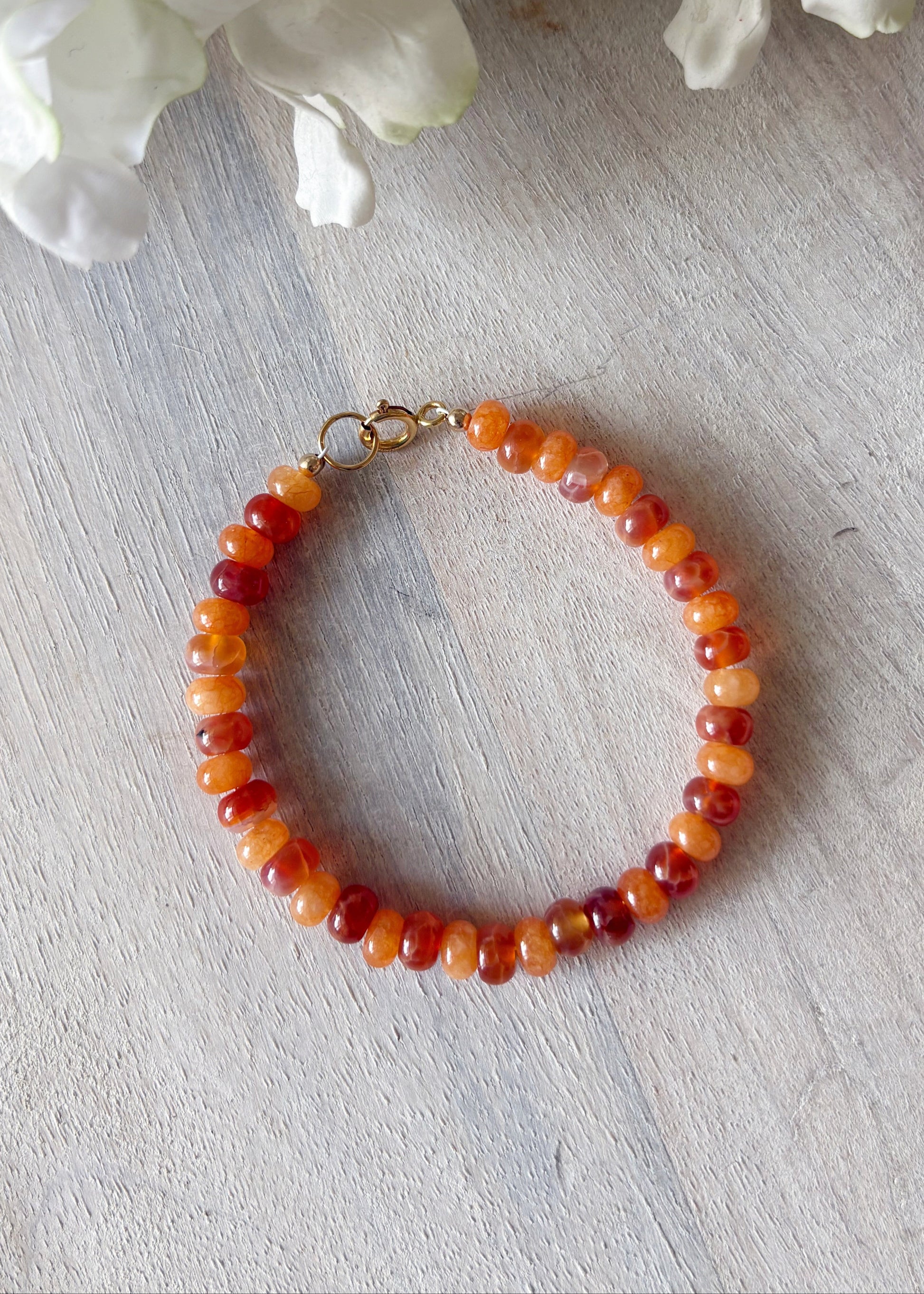 Carnelian Bracelet with round orange and red beads and a gold clasp