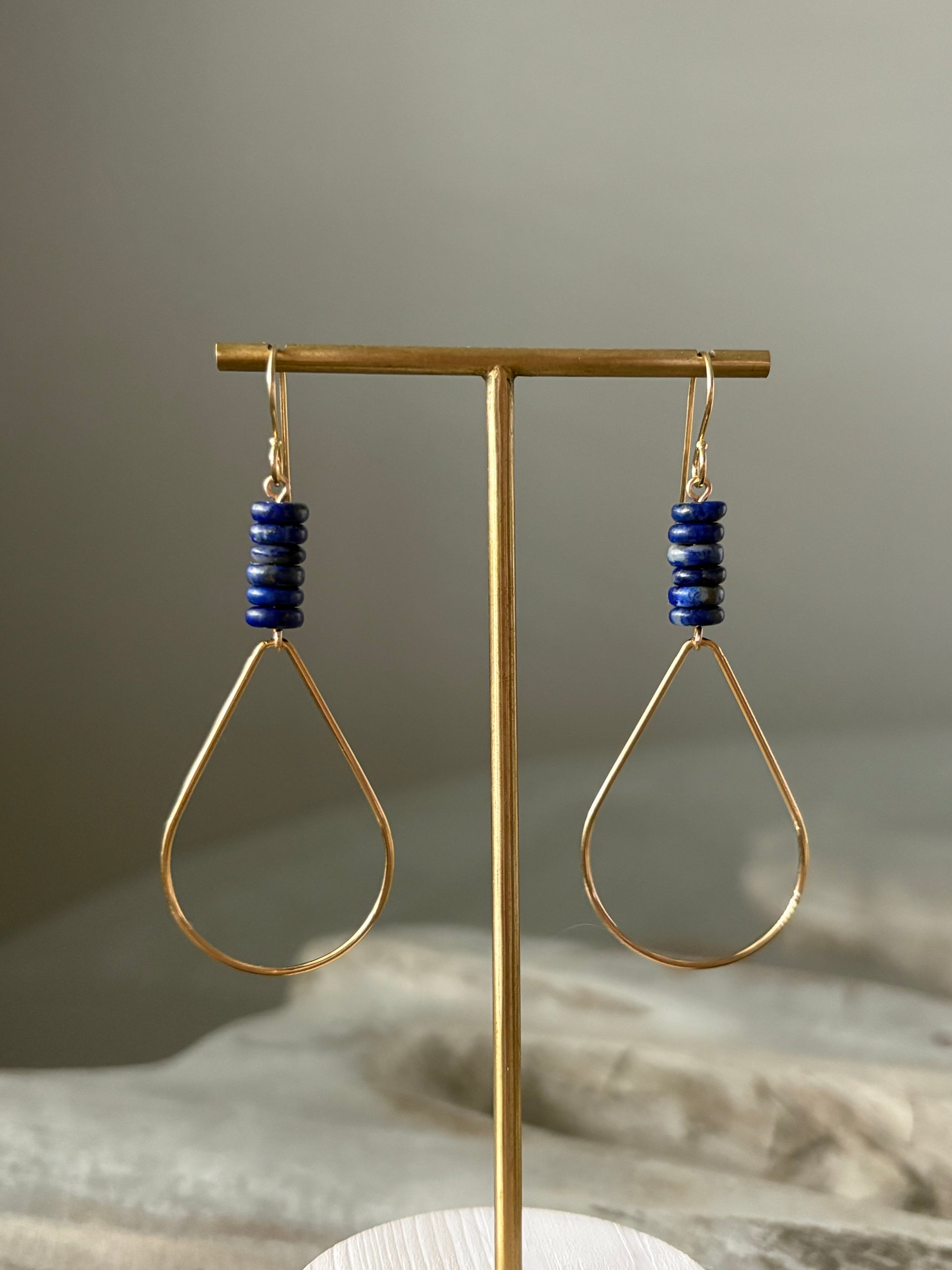 Lapis Gold Teardrop Earrings on a gold stand