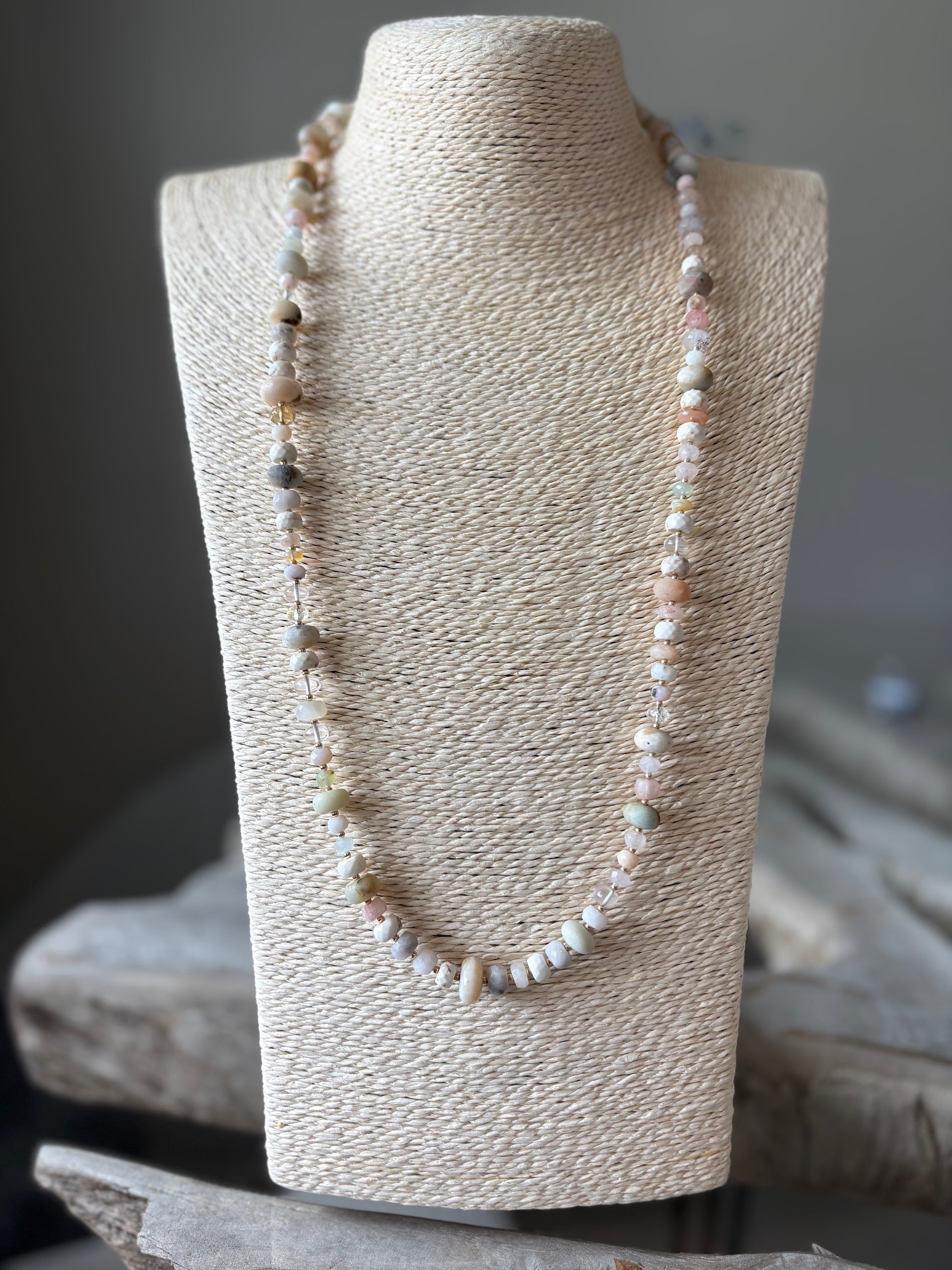 Necklace on a textured mannequin bust with a neutral background