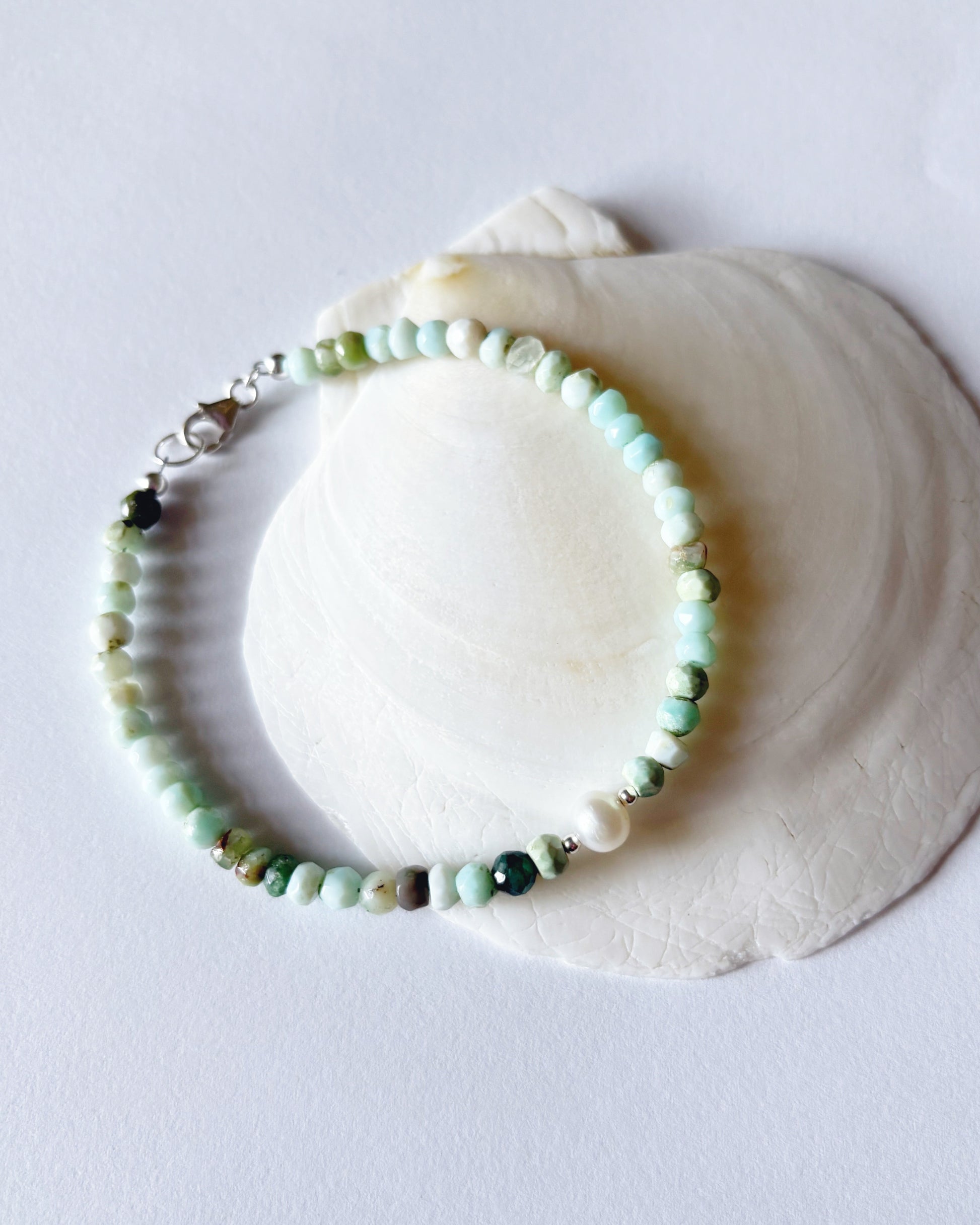 Beaded bracelet on a white shell against a light gray background