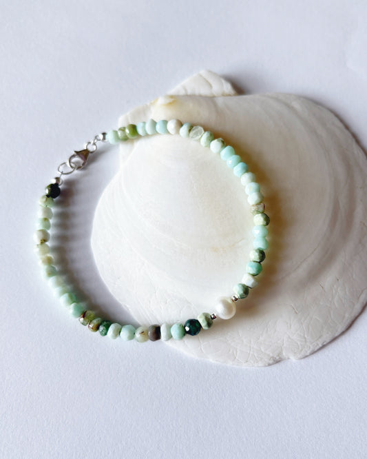 Beaded bracelet on a white shell against a light gray background