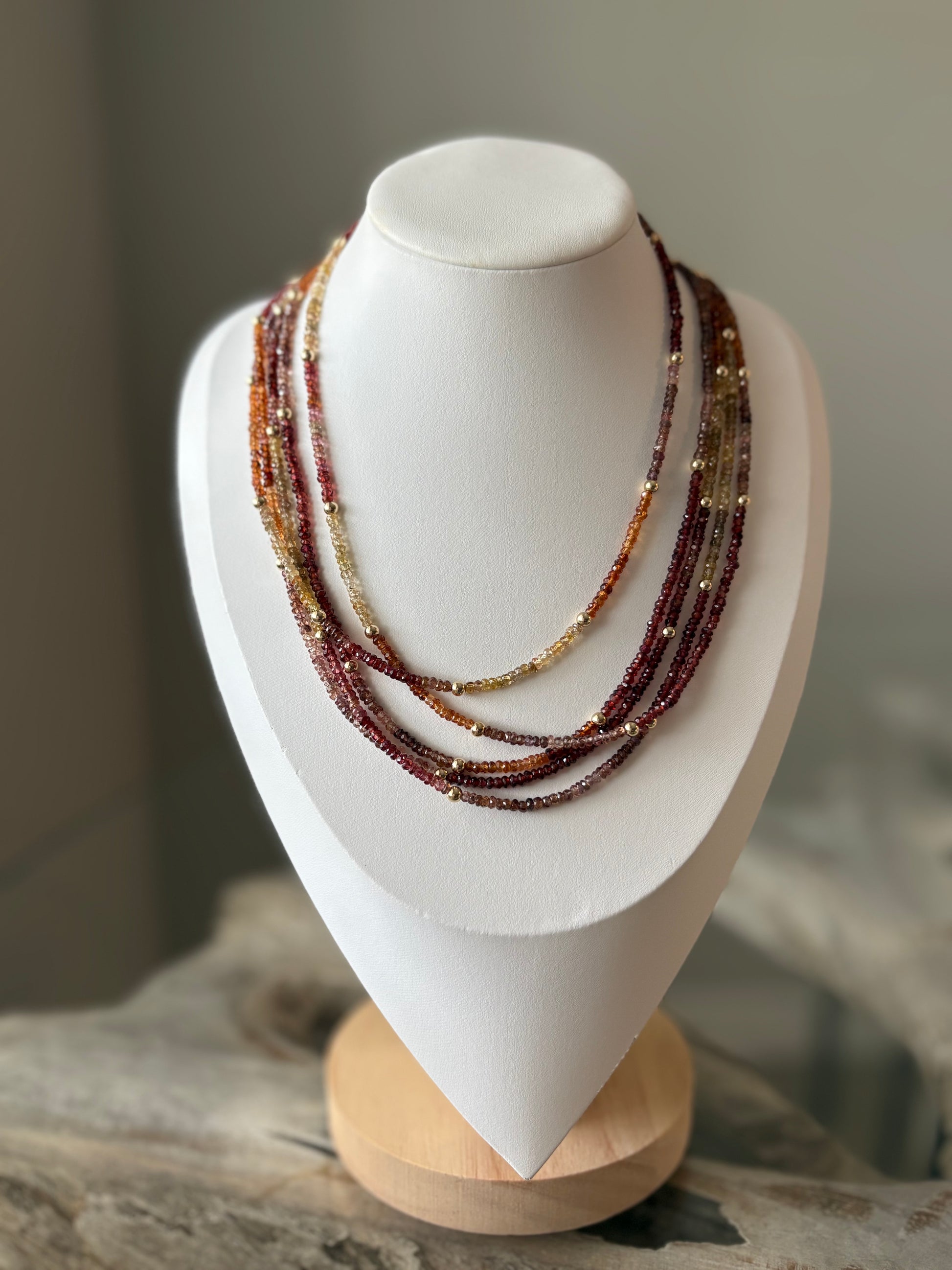Sapphire Necklace with multiple strands of small, faceted beads in shades of red, orange, and yellow