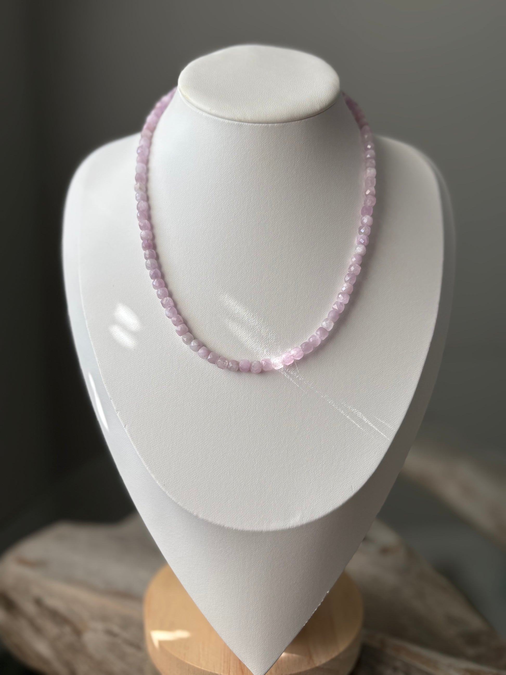 Kunzite Cube Necklace on a white display stand