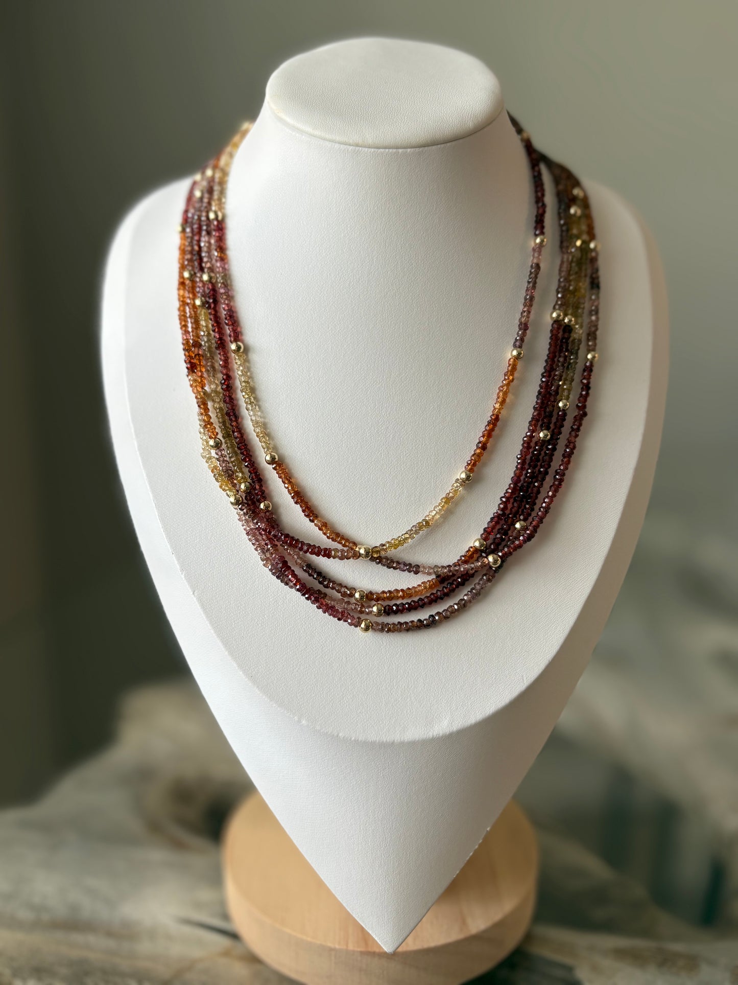 Sapphire Necklace with multiple strands of small, faceted beads in shades of red, orange, and yellow