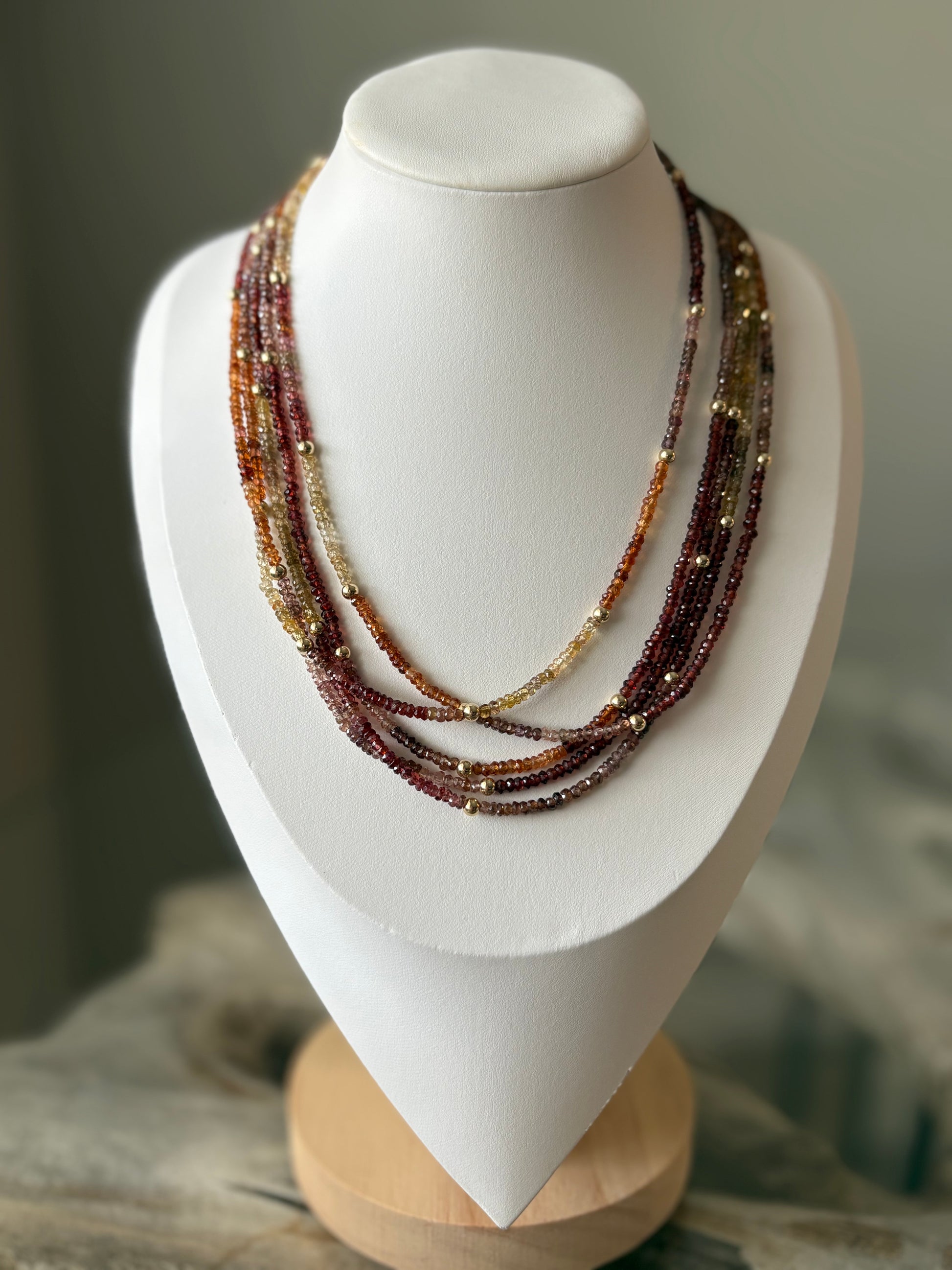 Sapphire Necklace with multiple strands of small, faceted beads in shades of red, orange, and yellow
