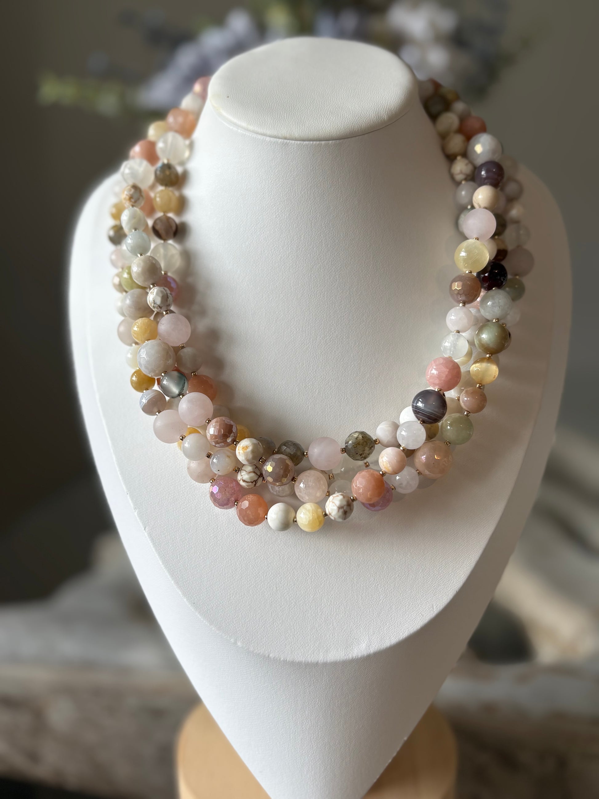 Beaded necklace on a white mannequin bust with a blurred background