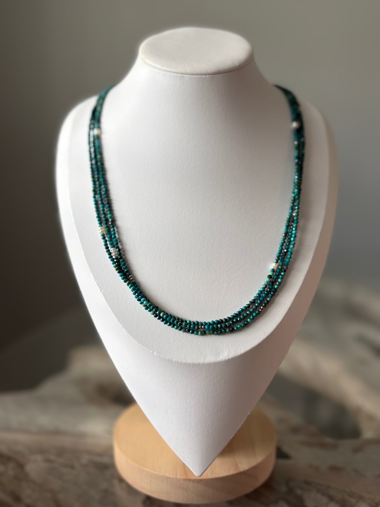 Long Chrysocolla Necklace with three strands of small, faceted teal beads and small silver beads