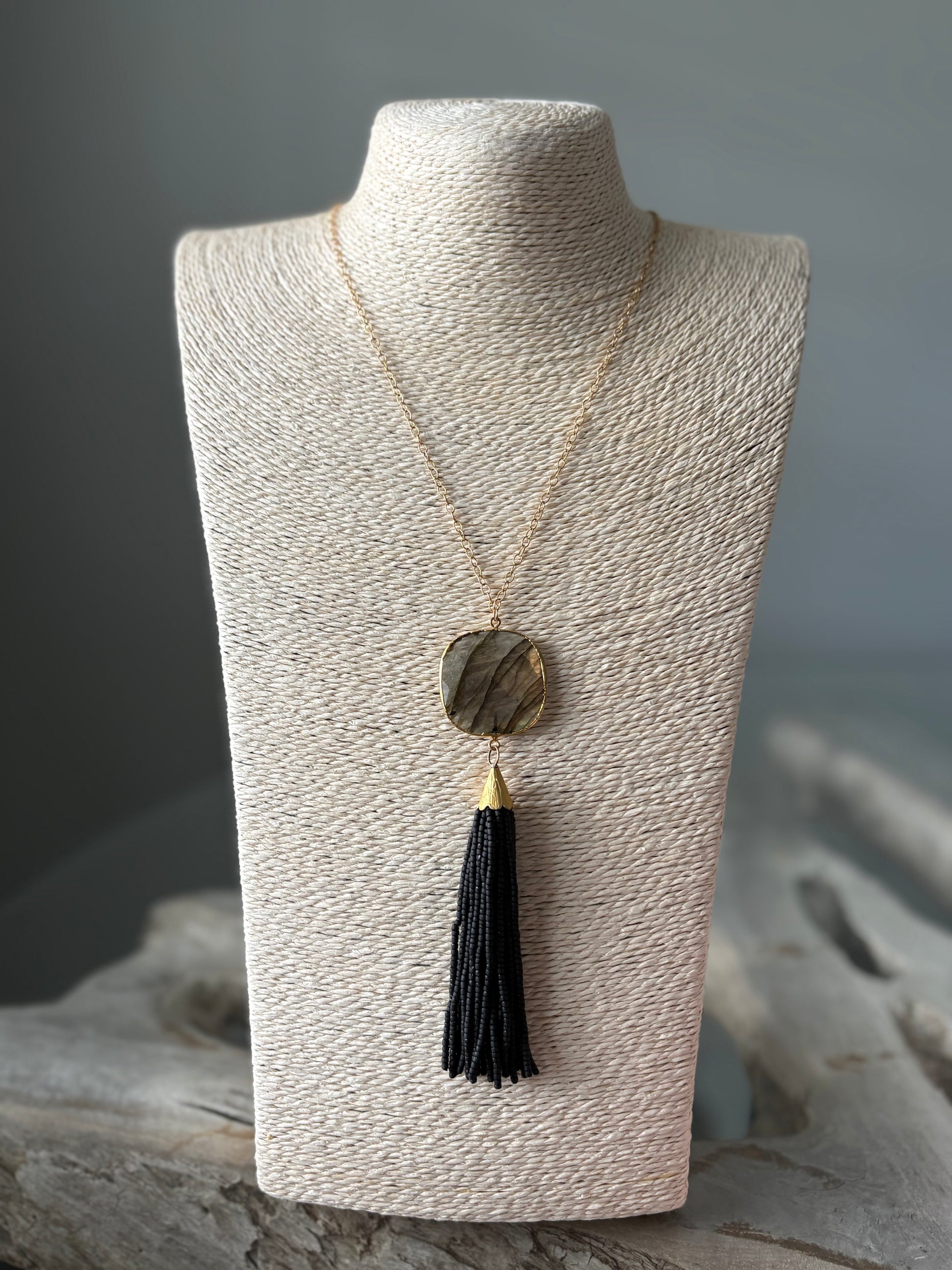 Black Tassel Necklace with a gold chain and a rectangular stone pendant
