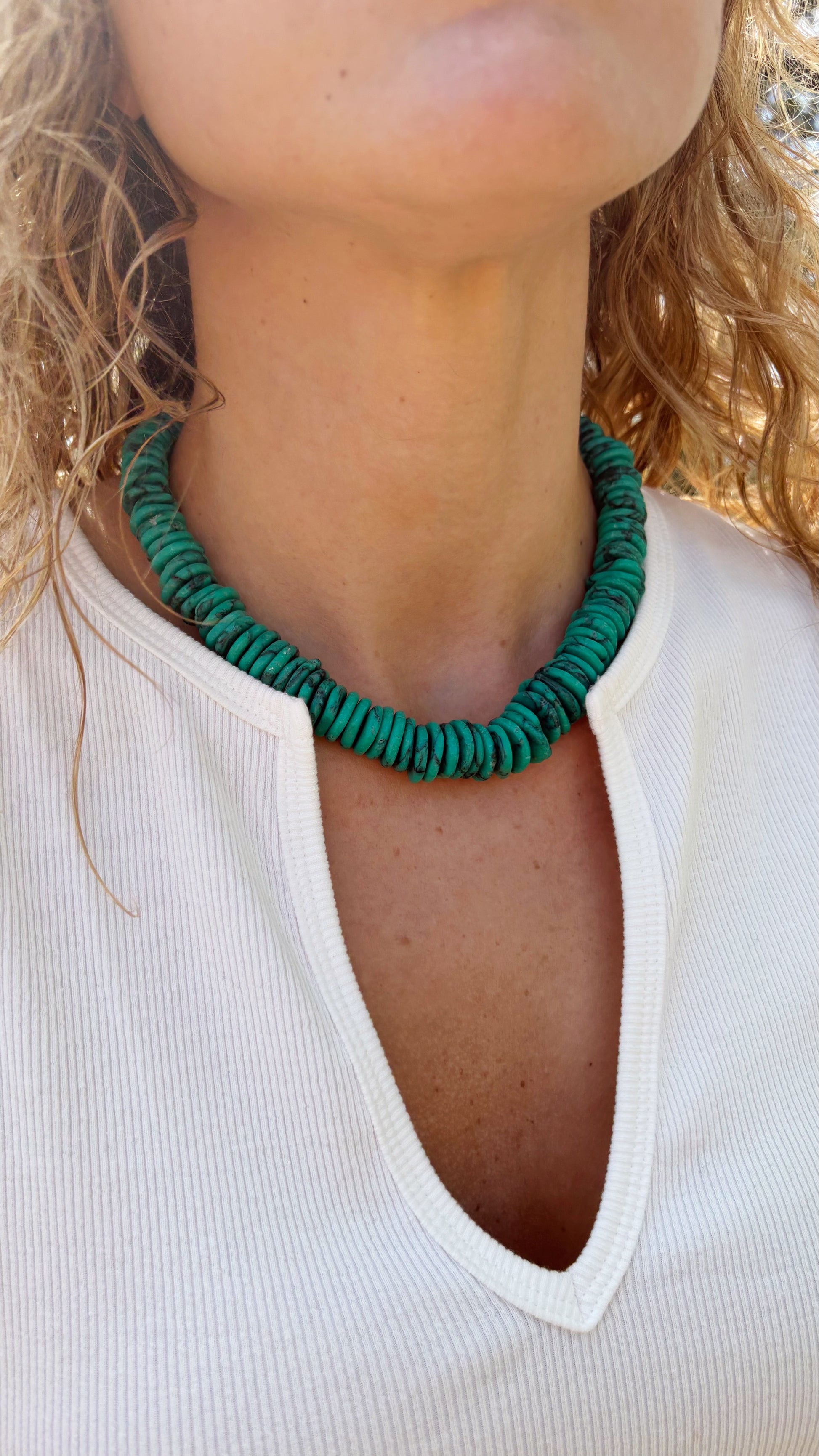 Bright green magnesite turquoise disc bead necklace worn on a person