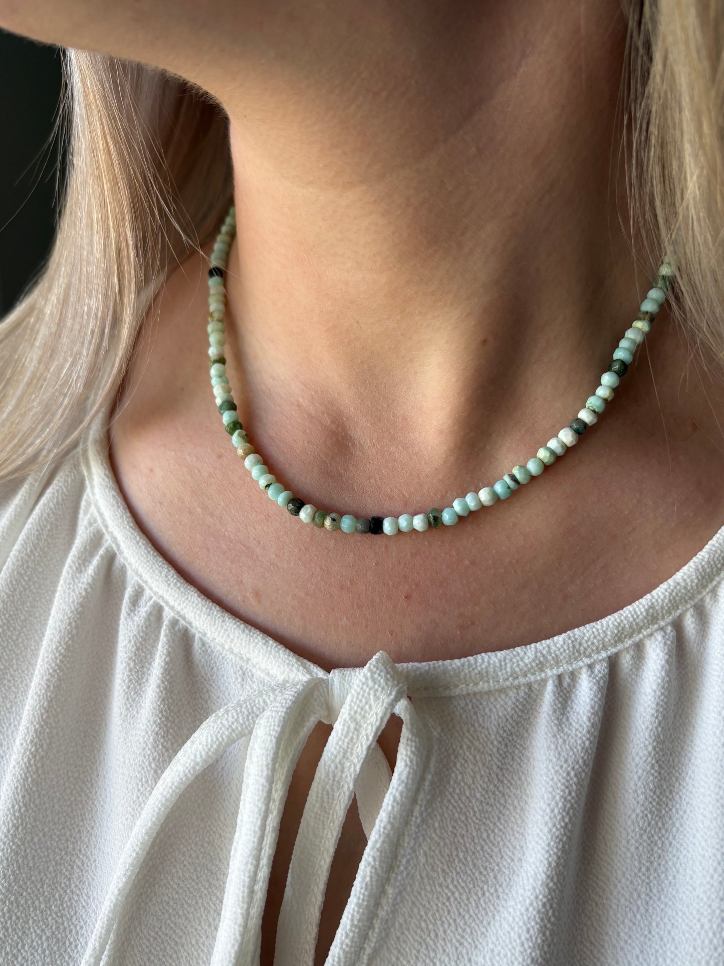 Peruvian Opal Gold Necklace with light blue and green beads on a woman's neck