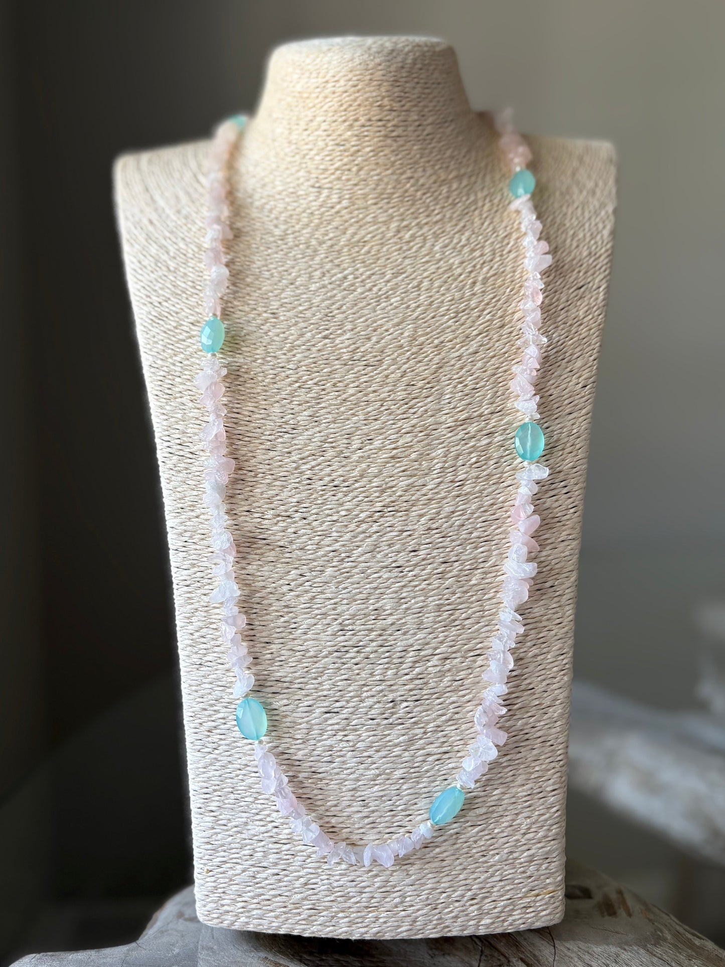 Necklace with turquoise beads on a mannequin bust against a neutral background
