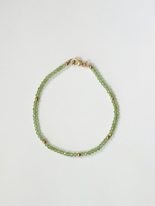 Green beaded bracelet on a light gray background