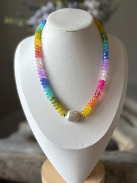 Colorful beaded necklace on a white mannequin bust with a blurred background
