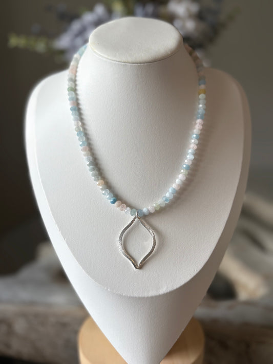 Necklace with a silver pendant on a white mannequin bust.