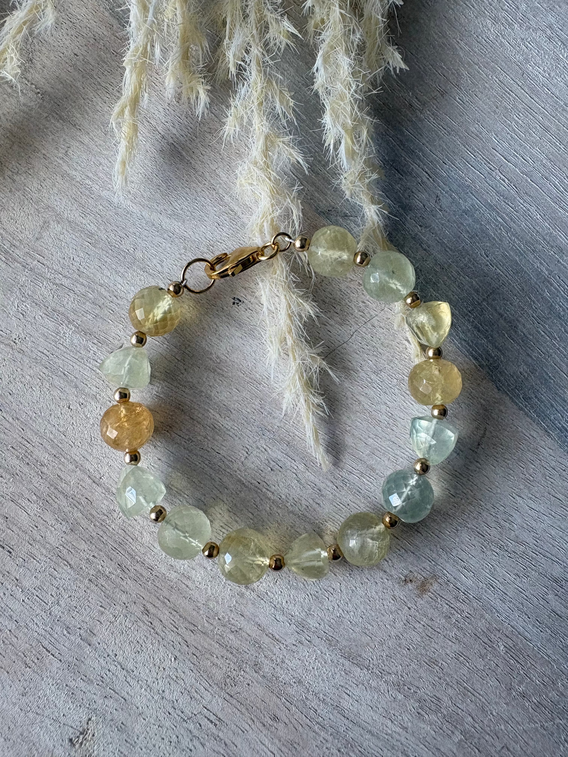 Glowing bracelet with green and yellow beads on a textured surface