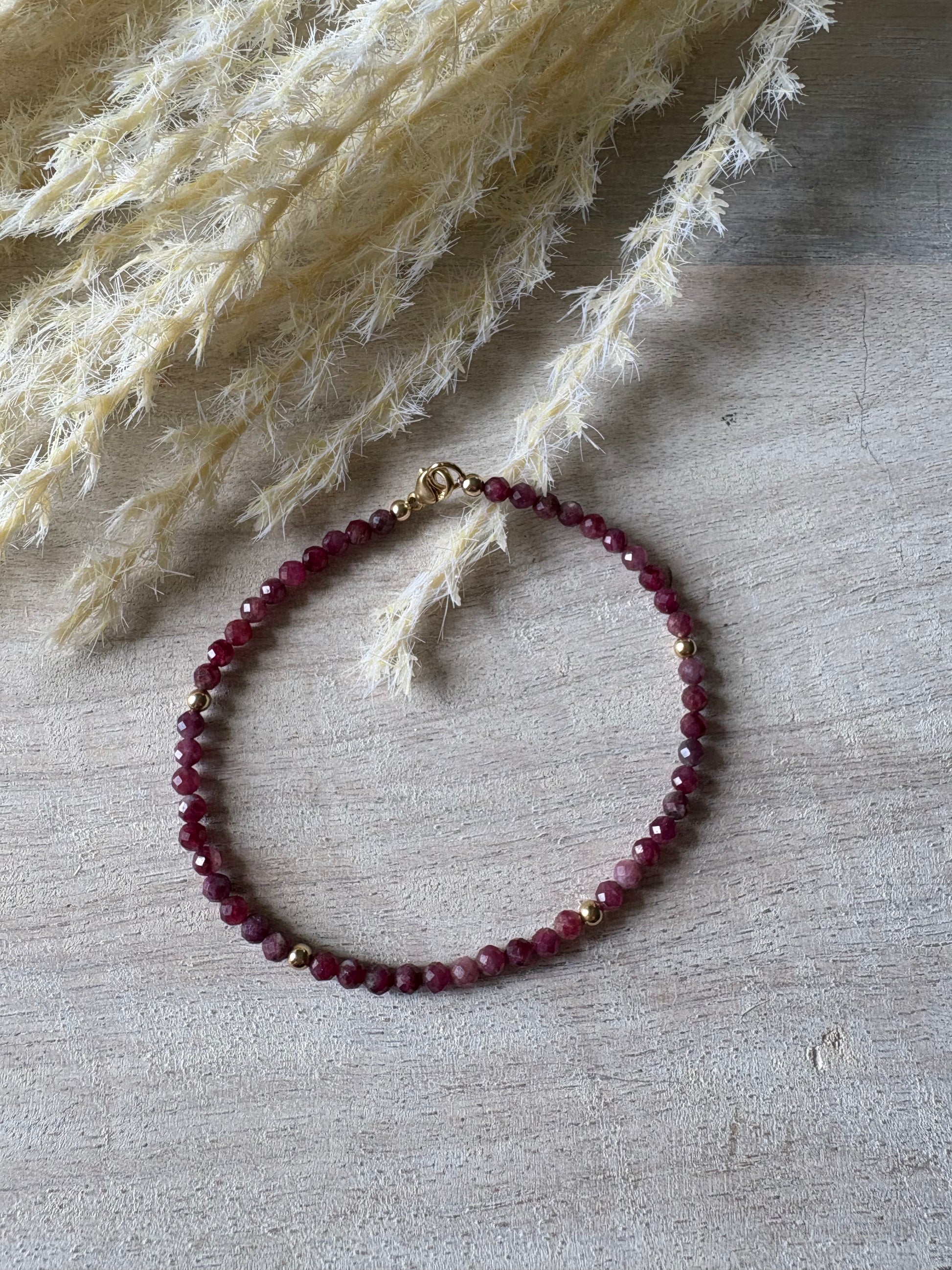 Beaded bracelet on a textured surface with dried plants