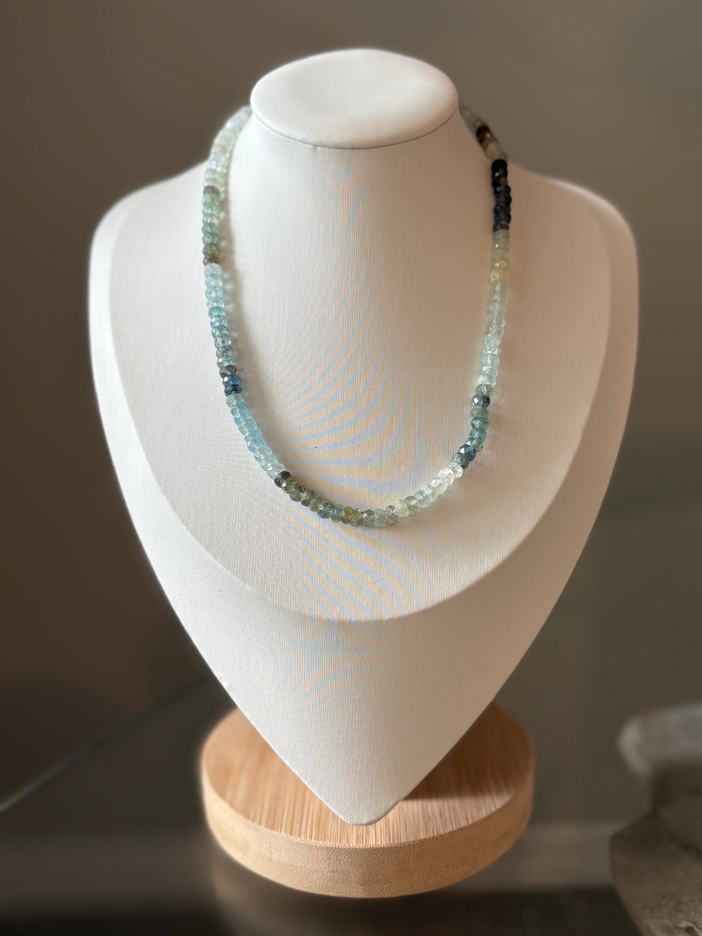 Moss Aquamarine Necklace 14 inch on a white display bust with a wooden base